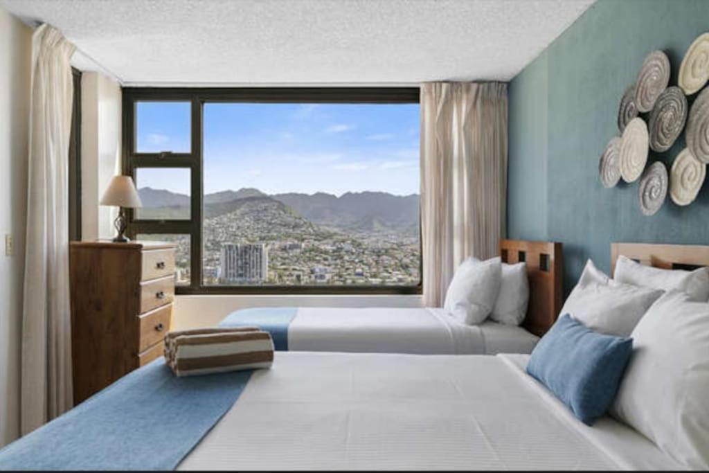 Habitación de hotel con 2 camas y ventana grande. en Views! Mountains, Canal, and City!, en Honolulu