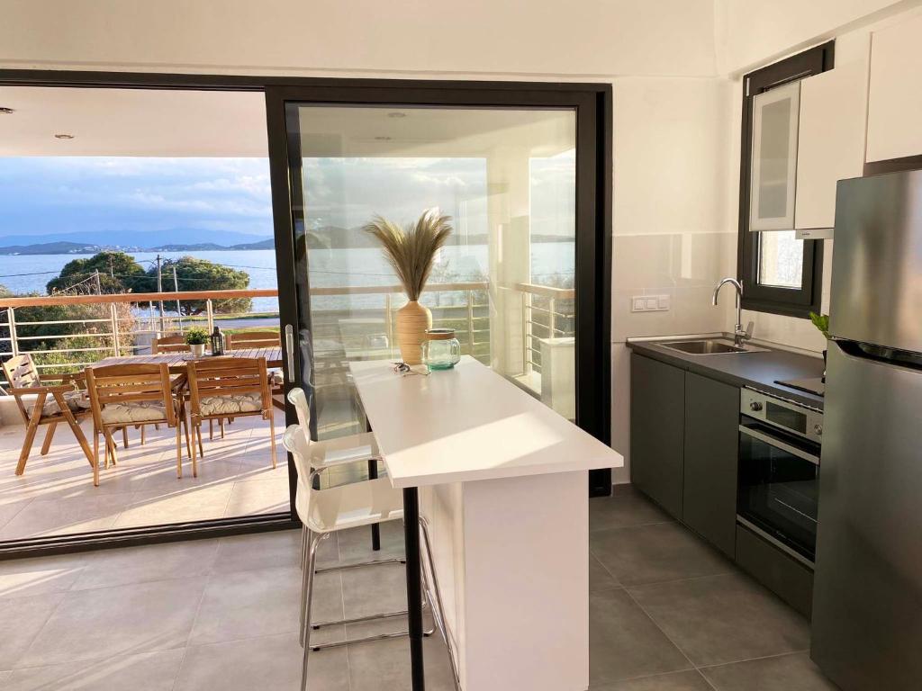 a kitchen with a view of a patio with a table at Casa al Mare in Nea Roda