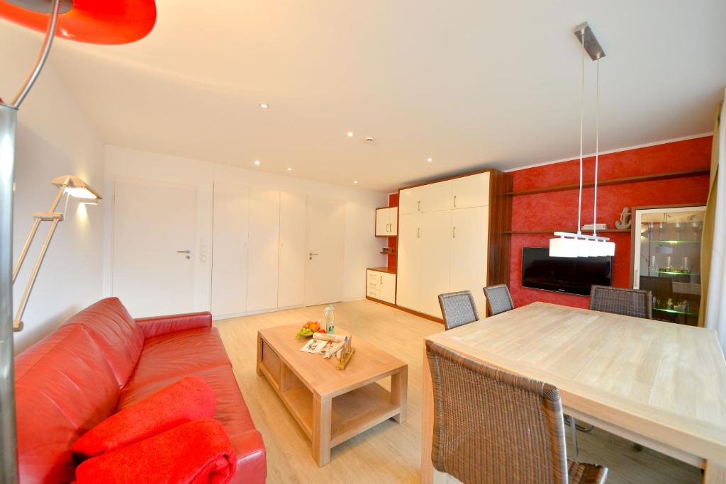 a living room with a red couch and a table at Haus Poseidon - Wohnung 1 1 in Wangerooge