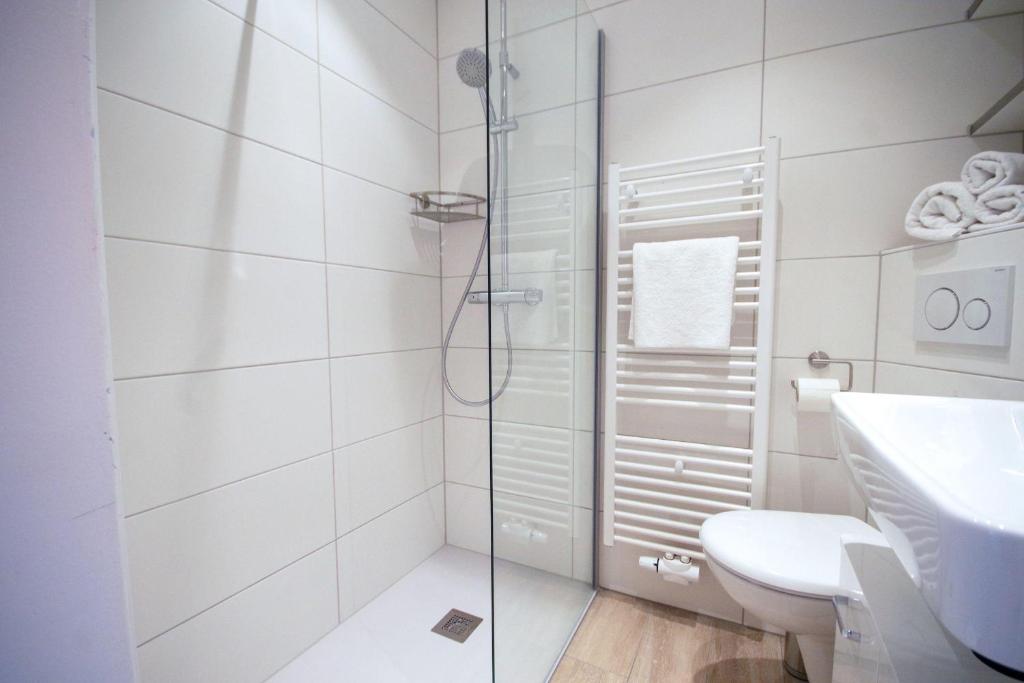 ein Bad mit einer Dusche, einem WC und einem Waschbecken in der Unterkunft Frische Brise 10.05 in Cuxhaven