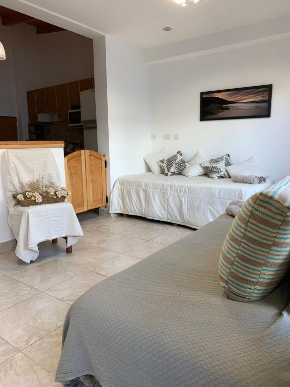 una camera d'albergo con due letti e una sedia di Espacio Alem a Comodoro Rivadavia