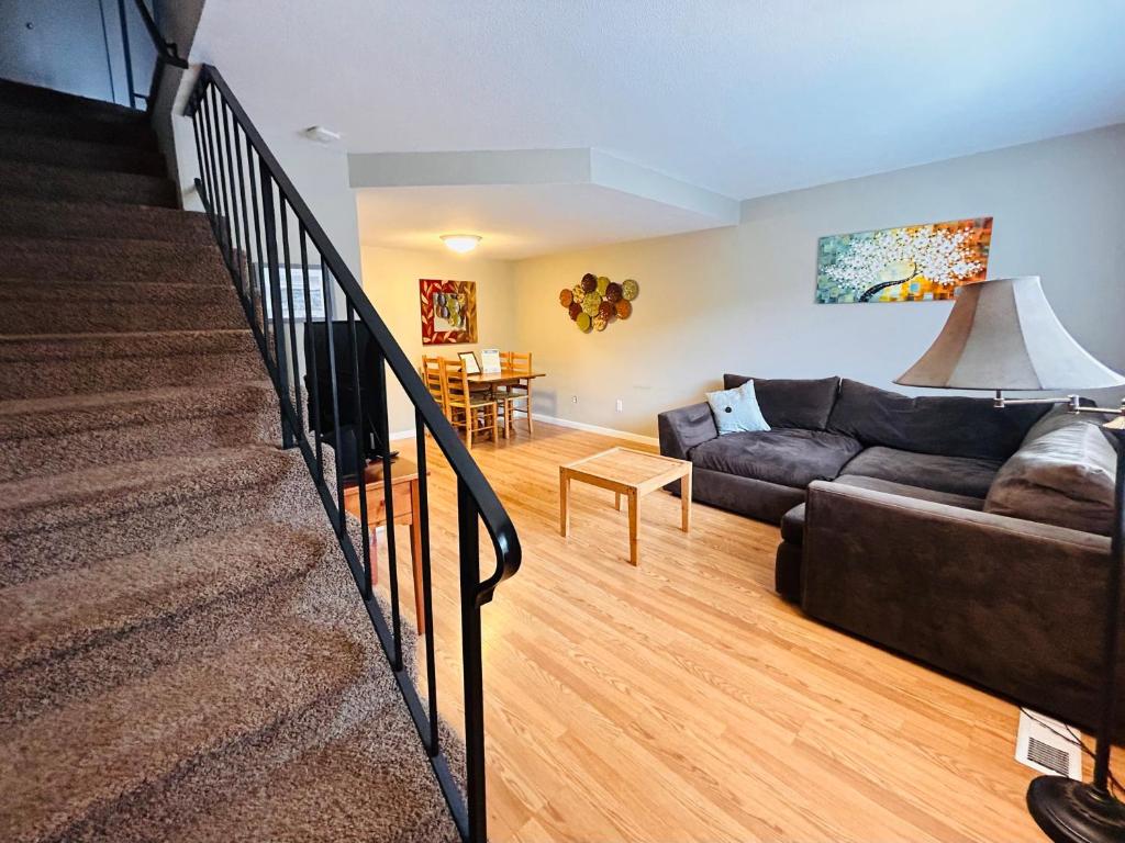 - un salon avec un canapé et un escalier dans l'établissement Luxe on Penn Family Friendly, Toddler amenities, baby proof with baby gate, toys, bath toys, cups and plates, Separate Workstation with Desk and Monitor, located in desirable SE Boise next to the Greenbelt and Boise River, à Boise