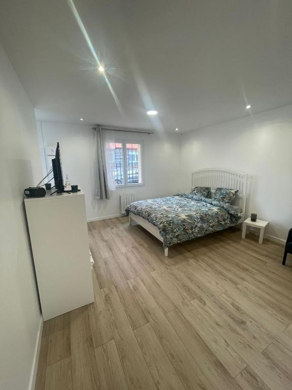 une chambre avec un lit et une télévision dans l'établissement Studio proche Stade de France, à Saint-Denis