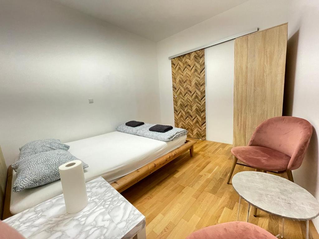 ein kleines Schlafzimmer mit einem Bett und einem Stuhl in der Unterkunft Nice rooftop hostel in Wien