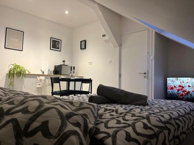 ein Schlafzimmer mit einem Bett und einem Tisch in einem Zimmer in der Unterkunft COSY RENT Appartment Strasbourg station Tv Wifi in Straßburg