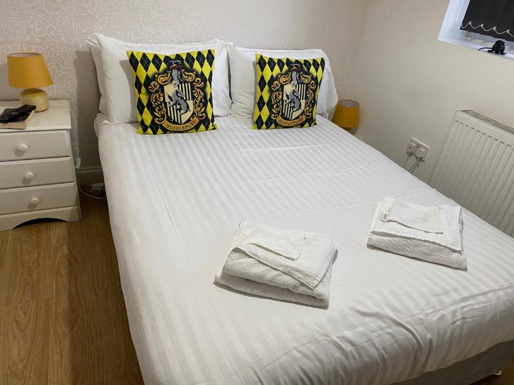 Una cama con dos toallas encima. en Spinners End, en Watford