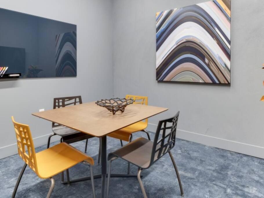 a dining room table with chairs and a painting at Jack London square stylish luxury 1BD apartment in Oakland