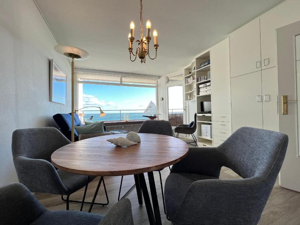 Una sala de estar con mesa de comedor y sillas. en Strandhotel-56, en Dahme