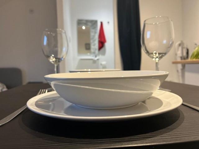 un tazón blanco y dos copas de vino en una mesa en Cosy Rent Strasbourg TV Wifi Studio Gare 4, en Estrasburgo