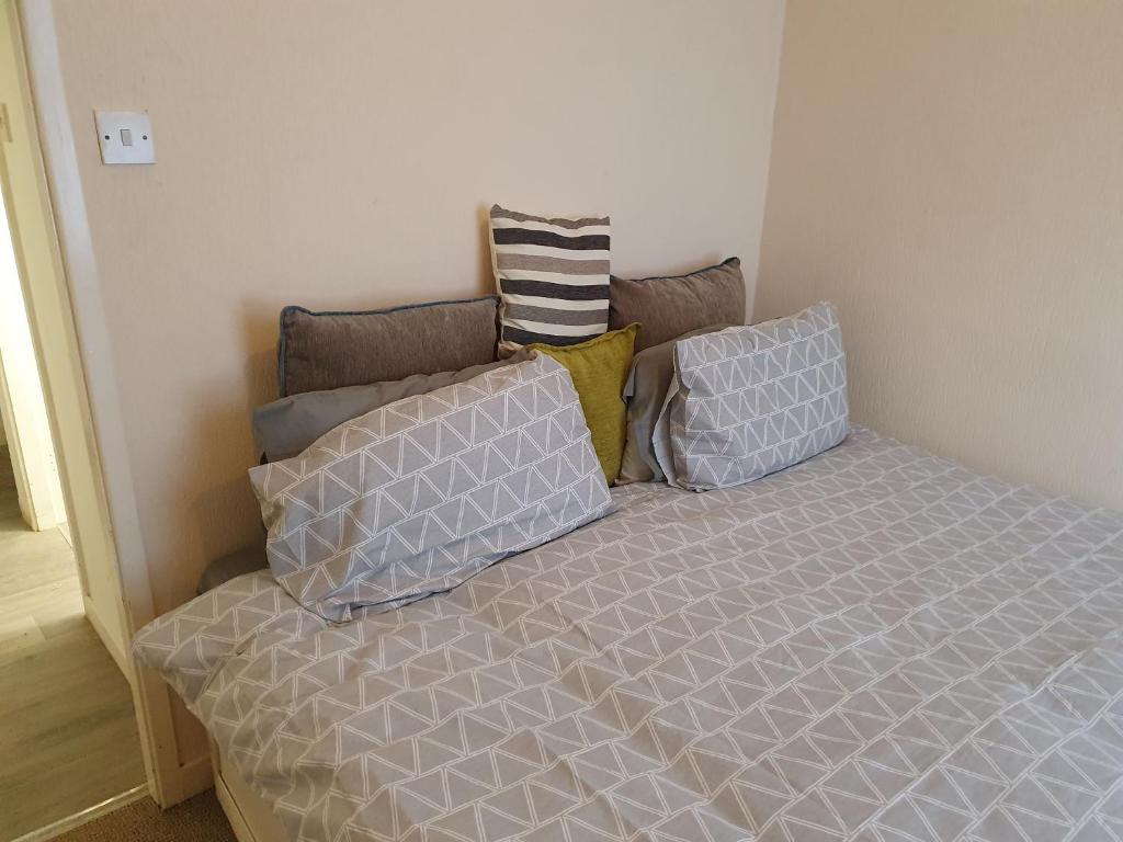 een bed met kussens in een kamer bij Litherland Apartment in Litherland