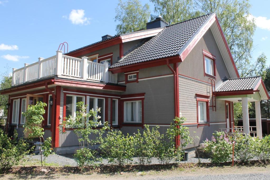 a red and white house with a balcony at Eräjärven Eerola Guesthouse in Eräjärvi