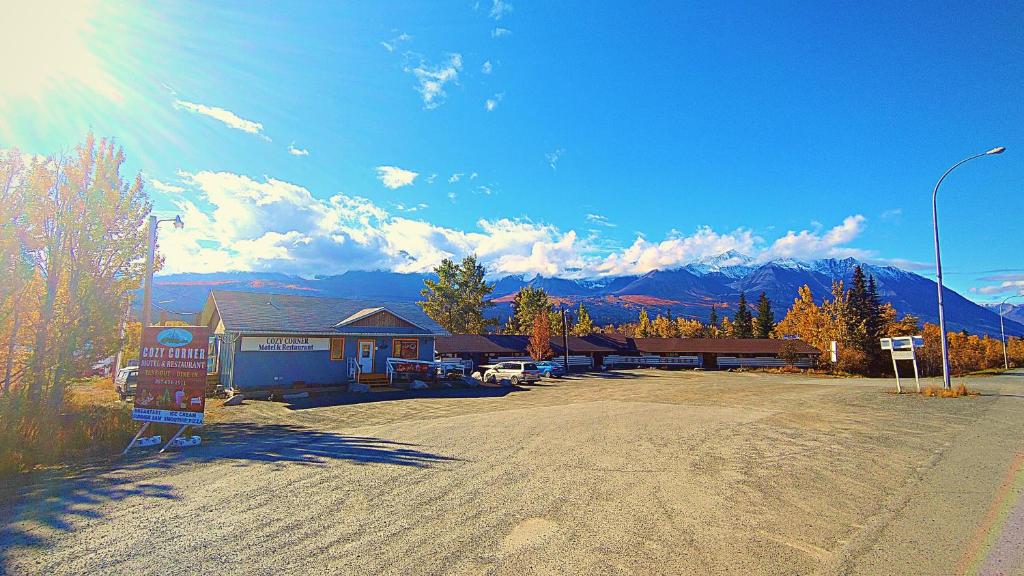 a parking lot in front of a building with mountains at Cozy Corner Motel & Restaurant in Haines Junction