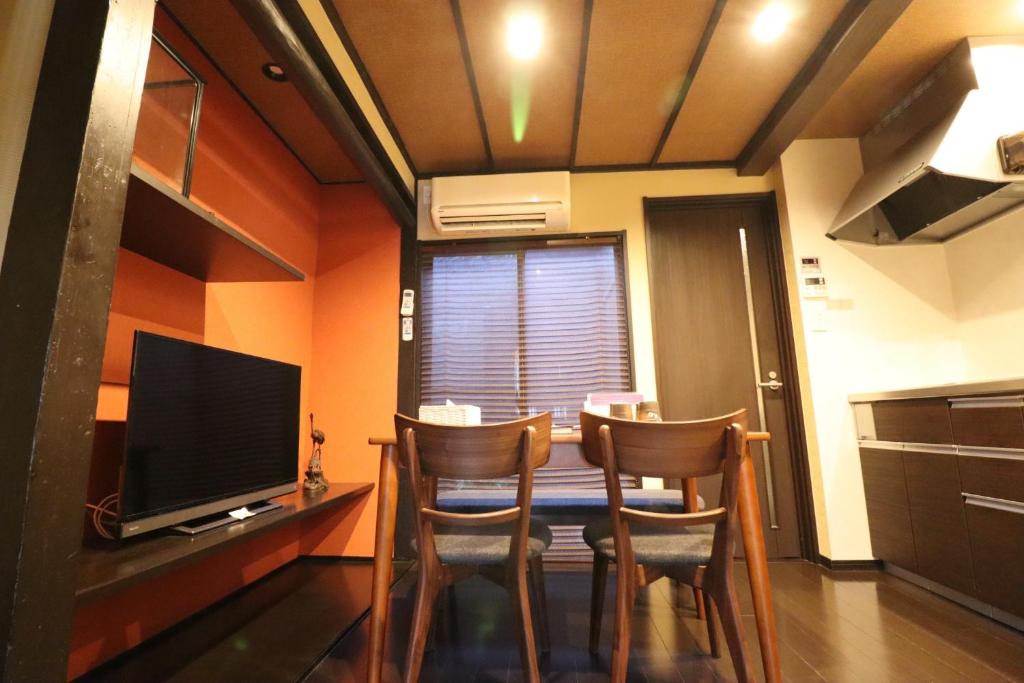 a dining room with a table with chairs and a television at Guest House Yuyu - Vacation STAY 61701v in Nishi-kujō-Toriiguchichō