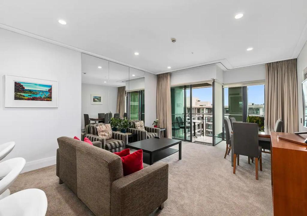 a living room with couches and a table at Sophisticated Spacious APT w Stunning Harbour View in Auckland