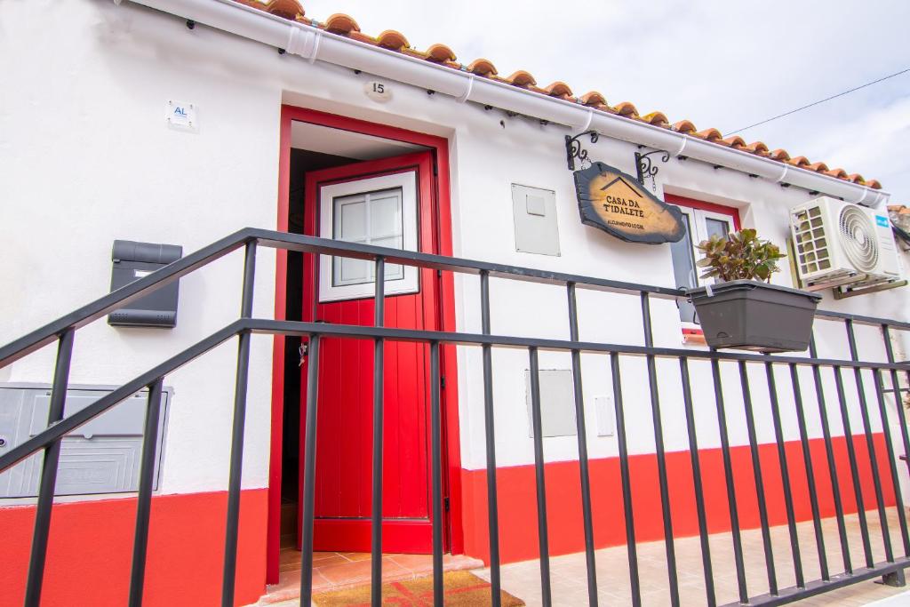 a red and white building with a red door at Casa da T´Idalete in Ourique