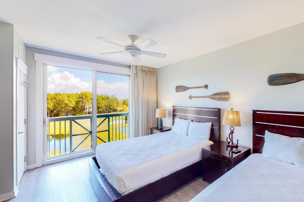 1 dormitorio con 2 camas y ventana grande en Elation #5316, en Destin