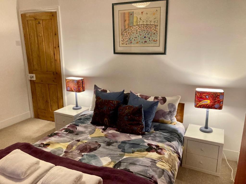 a bedroom with a bed with two lamps on tables at Comfortable stylish room in Hanwell in Greenford