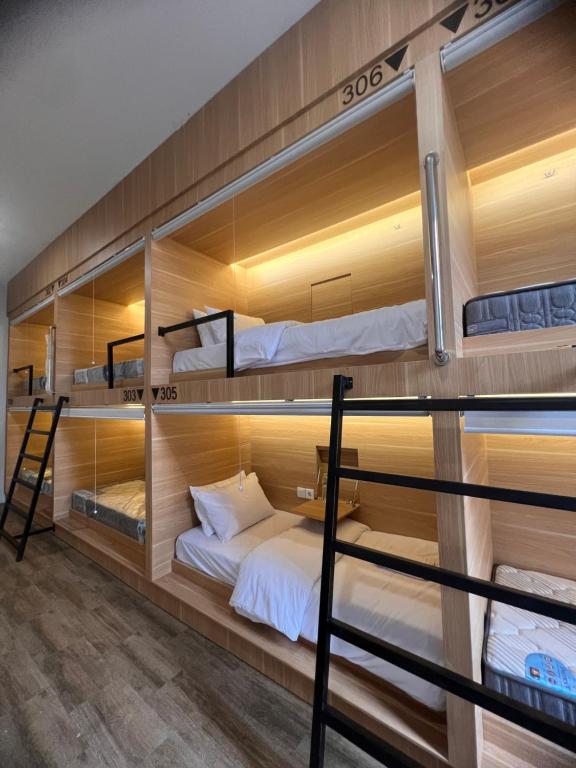 Cette chambre dispose de lits superposés en bois et d'un lit. dans l'établissement Sleep Studio Hotel City Center Surabaya, à Tembok