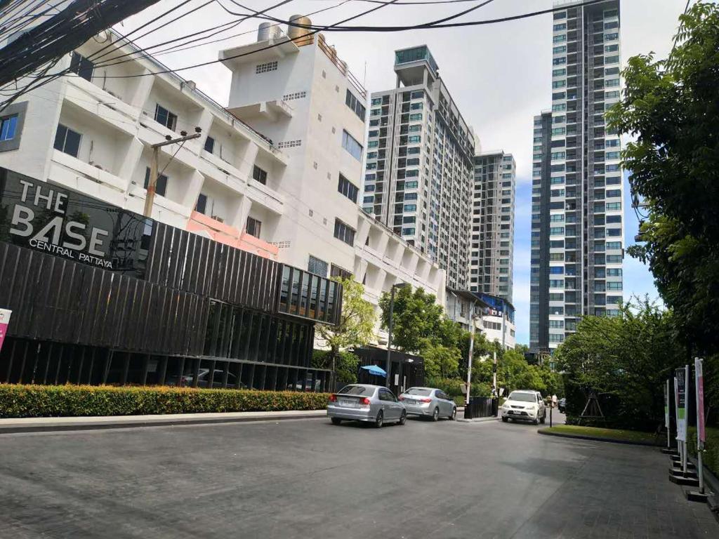 a city street with cars parked in front of tall buildings at The Base Pattaya in Pattaya