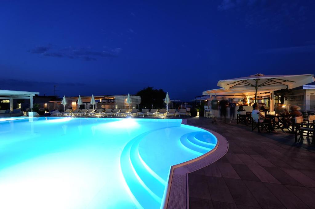 a large swimming pool at night with the number seven at Hotel Caesar in Lido di Savio