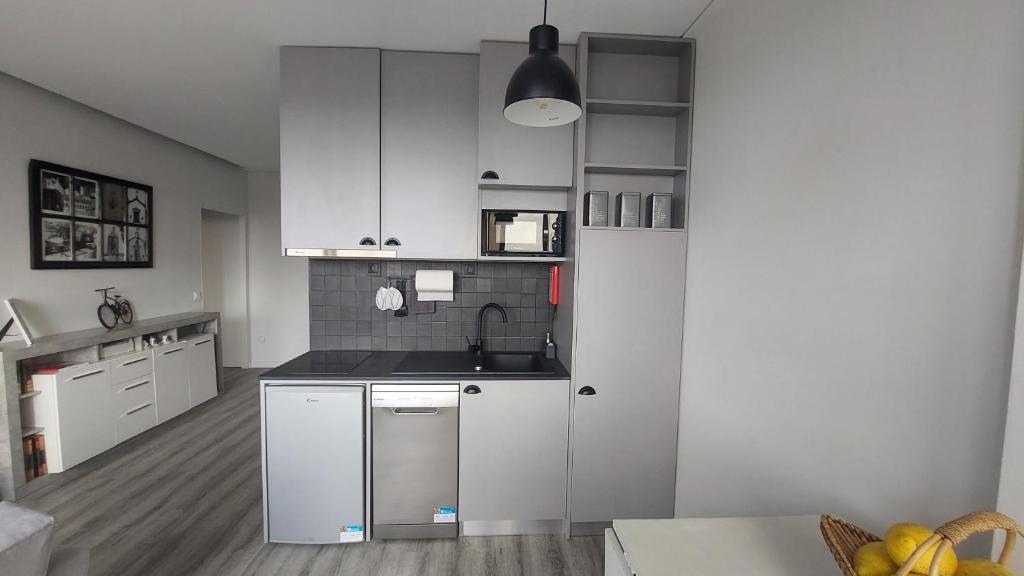 a kitchen with white cabinets and a sink at Maia Apartment in Maia