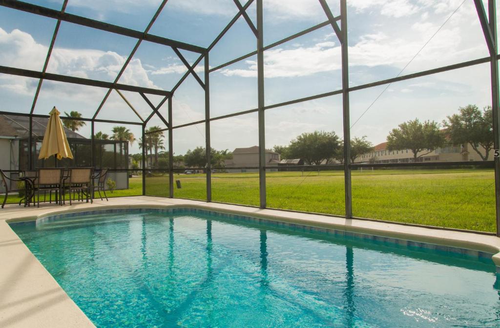 a swimming pool in a house with a large window at Gated Community!! Sparkling Private Pool, Near Disney in Kissimmee