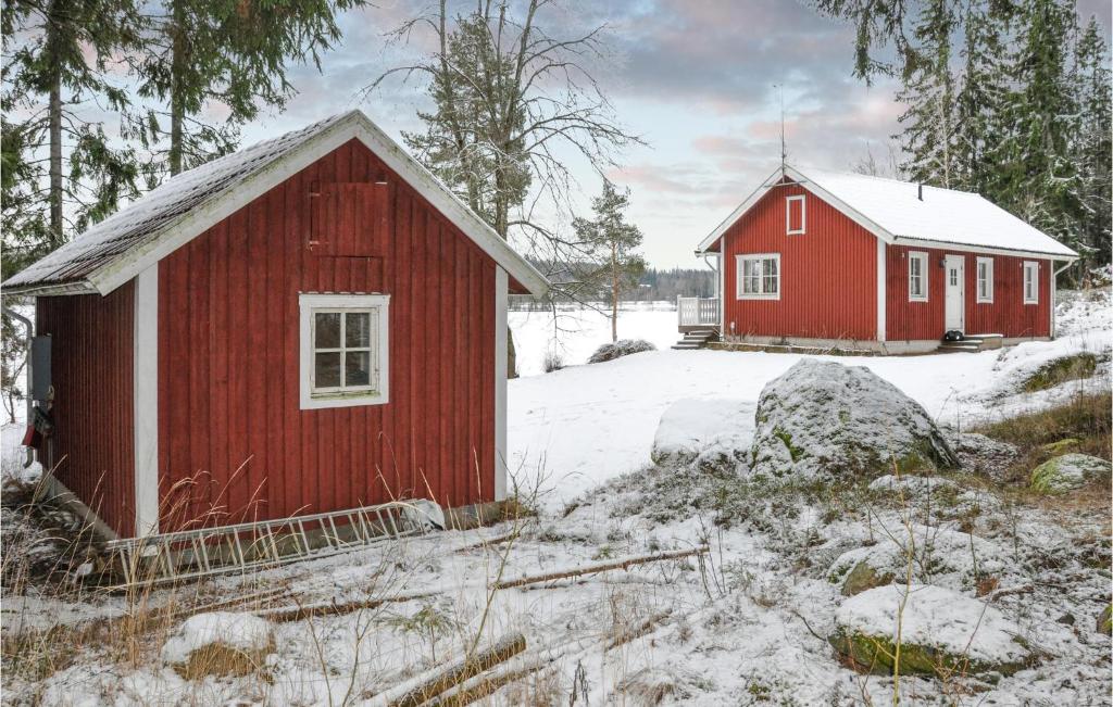 un granero rojo y una casa roja en la nieve en Amazing Home In Kristinehamn With Wifi, en Rådetorp