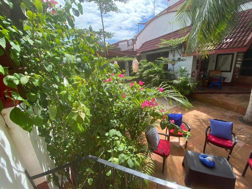 a patio with chairs and flowers and a house at Villa del Mar in Mactan