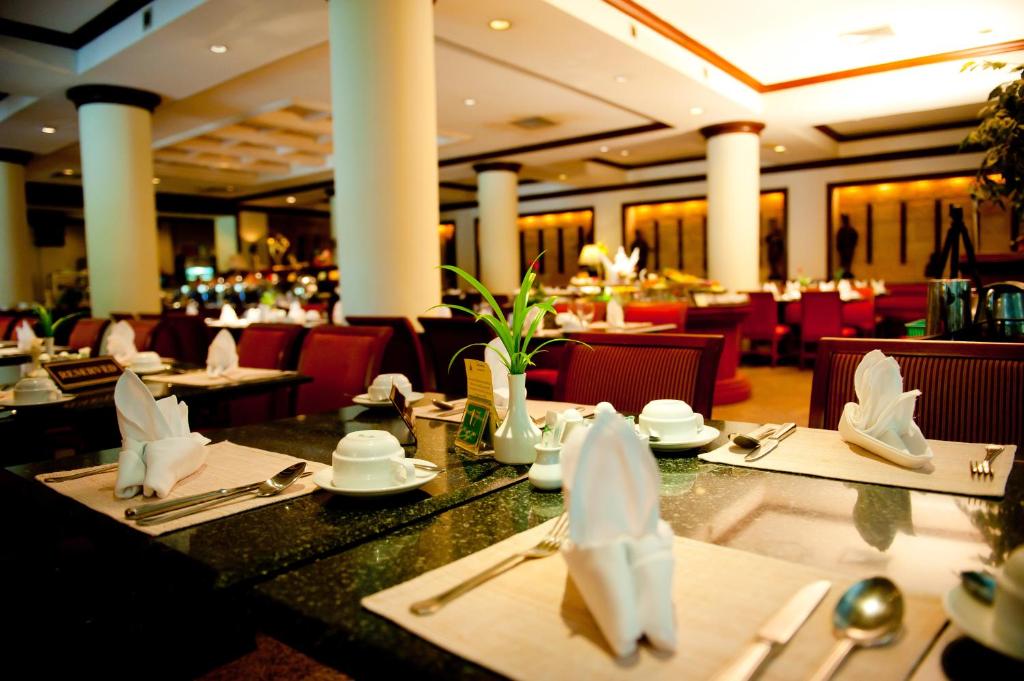 uma sala de jantar com mesas e cadeiras num restaurante em Wiang Inn Hotel em Chiang Rai