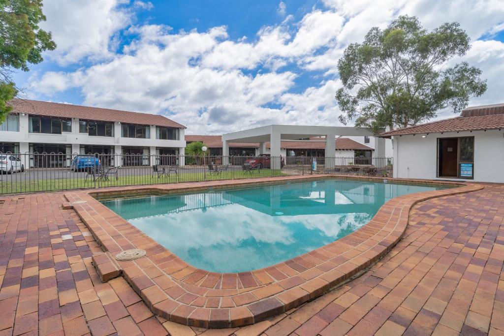 a swimming pool in front of a building at All Seasons Motel Armidale in Armidale