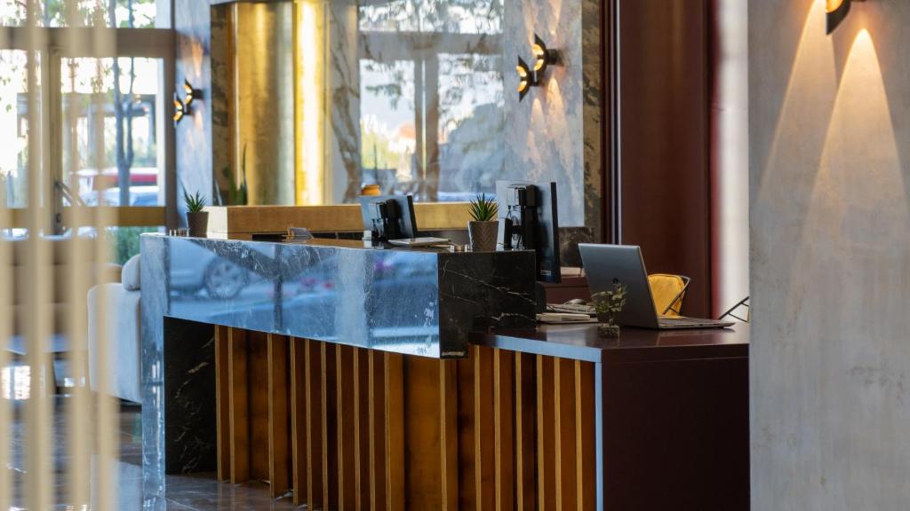 a lobby with a desk with a laptop on it at Doanesia Premium Hotel & Spa in Tirana