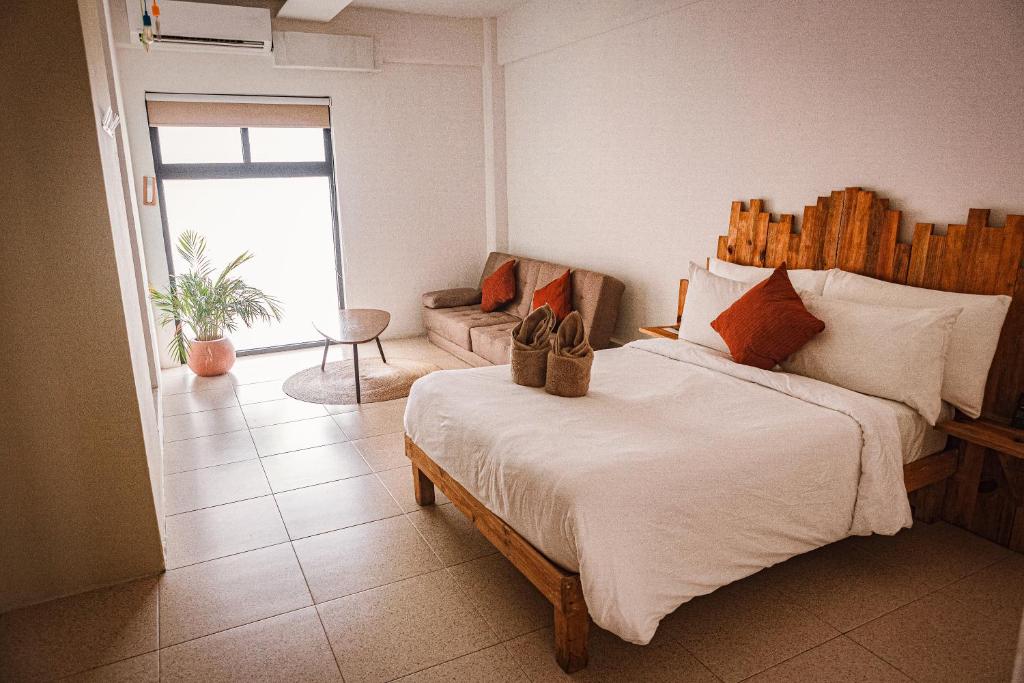 Un dormitorio con una cama grande con zapatos. en Nomads Hotel, Hostel & Rooftop Pool Cancun en Cancún