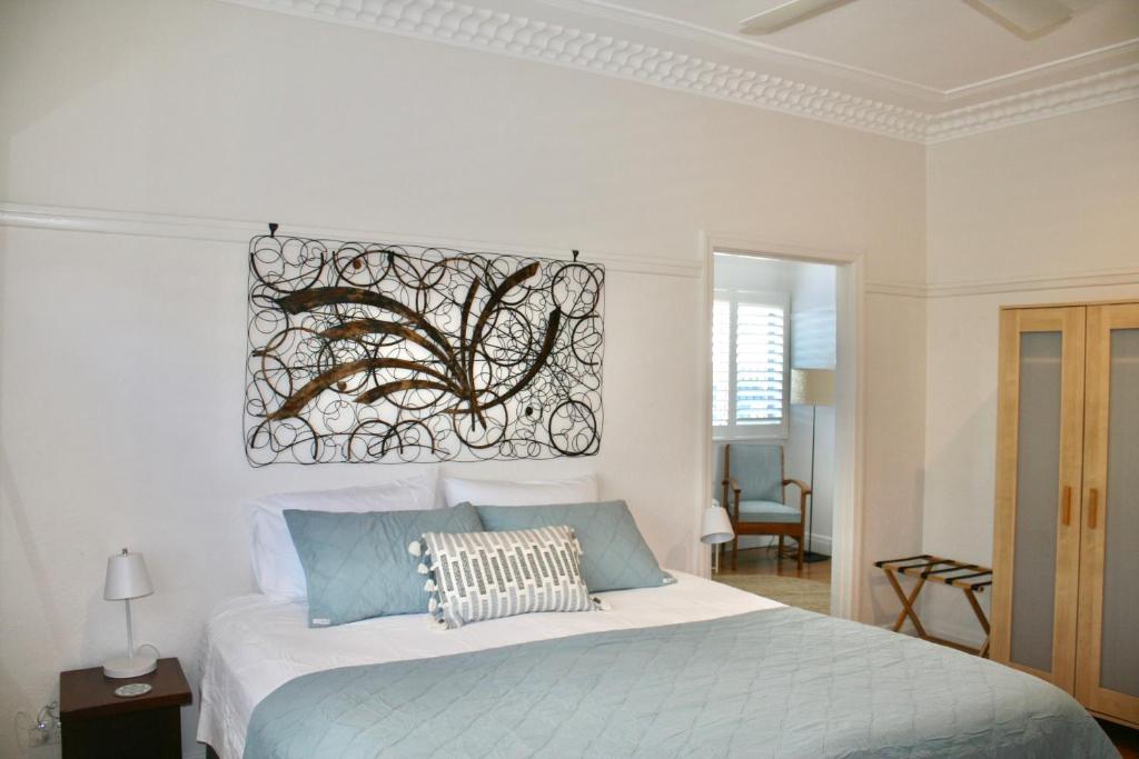 a bedroom with a bed with a picture on the wall at The Byron Bay Guesthouse in Byron Bay