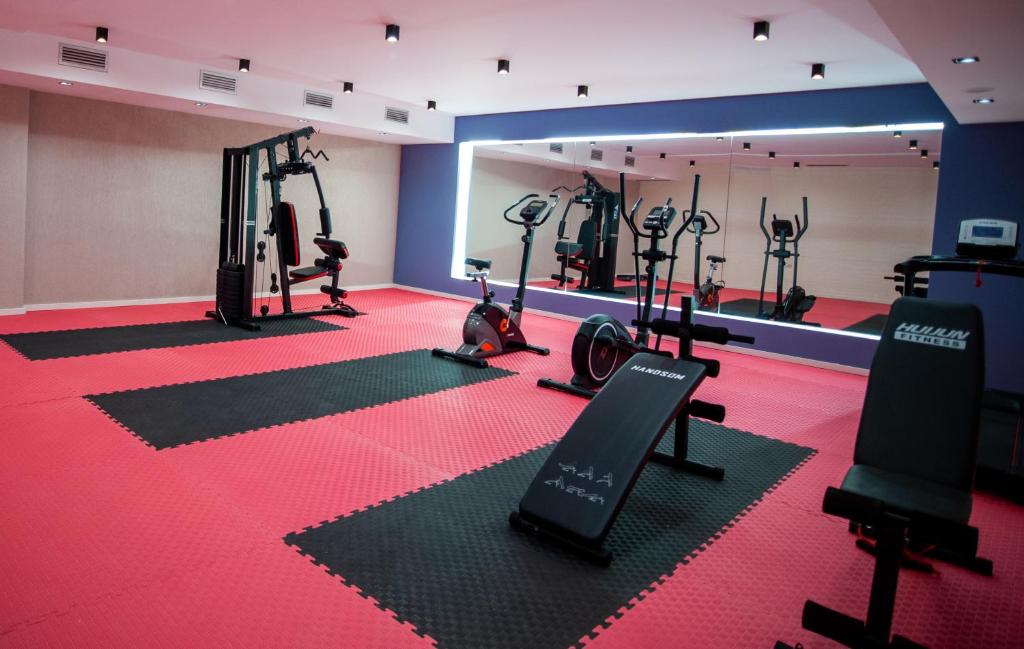 a gym with several tread machines in a room at Doanesia Premium Hotel & Spa in Tirana
