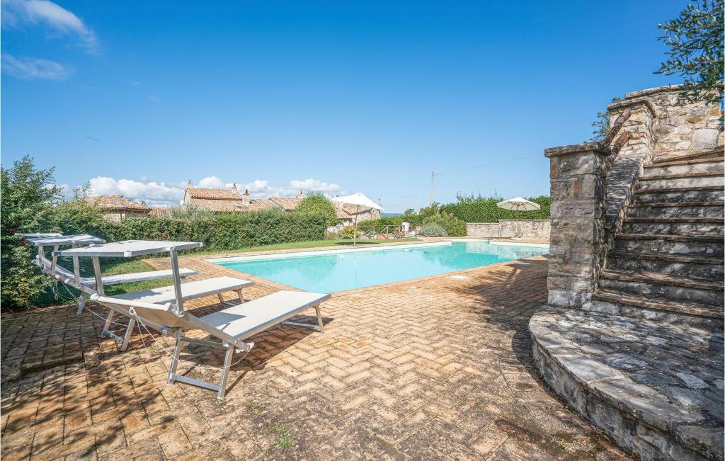 uma piscina com duas espreguiçadeiras ao lado de uma parede de pedra em Lorenzo em Acqualoreto