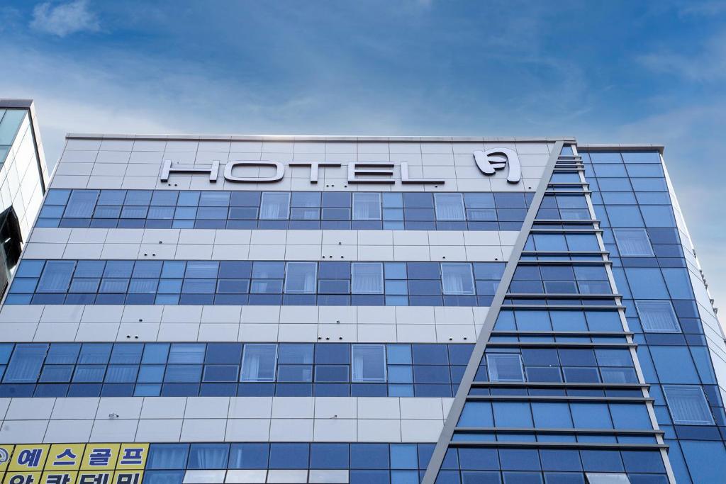 a hotel sign on the top of a building at Wall Hotel in Cheonan