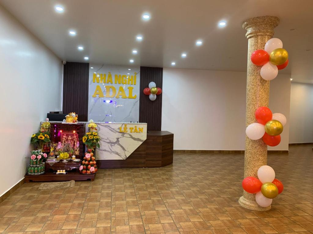 una habitación con una mesa con un cartel y globos en Adal Motel en Kiến An