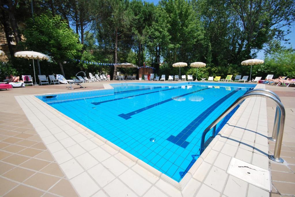 una grande piscina con pavimento piastrellato blu di Hotel Plutone a Cervia