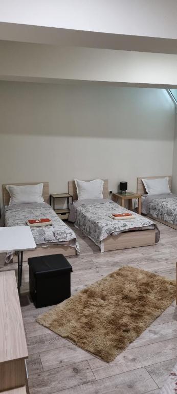 a large room with three beds and a rug at Guest rooms Super center PLOVDIV perfect location in Plovdiv