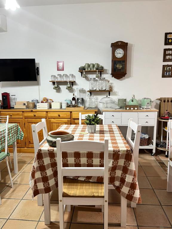 cocina con mesa, sillas y reloj en Le sorelle gemelle B&B, en Teramo