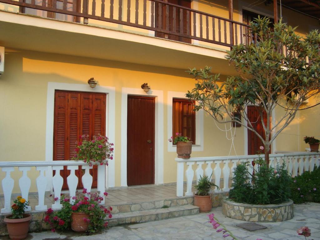 a house with stairs and flowers in front of it at Apartment Victoria in Agios Georgios