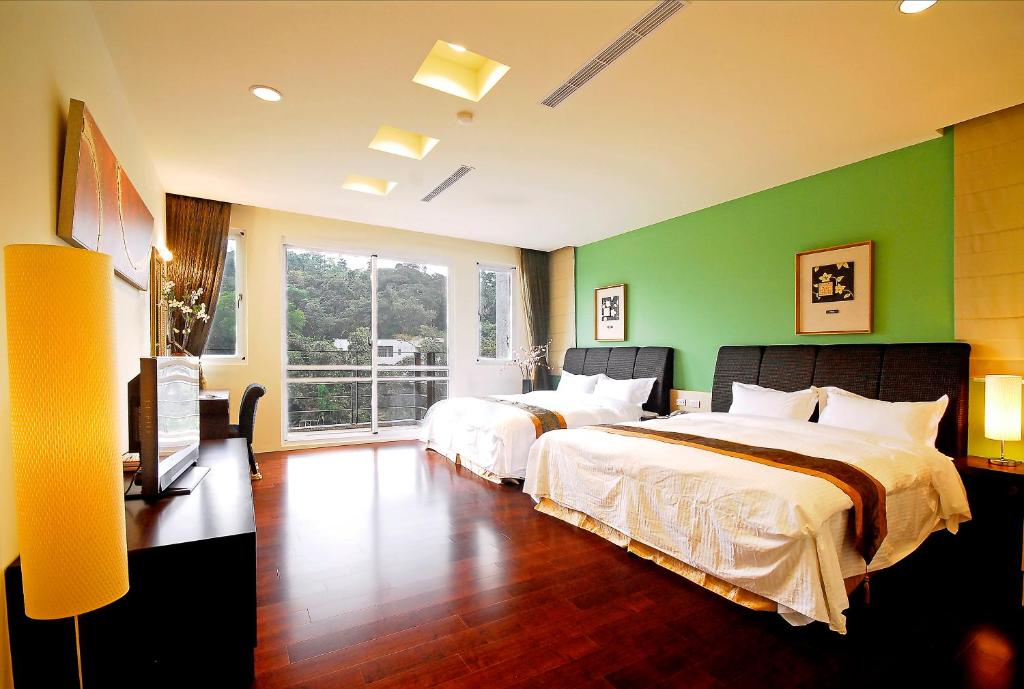 a bedroom with two beds and a green wall at Sun Moon Lake Karuizawa Villa in Yuchi