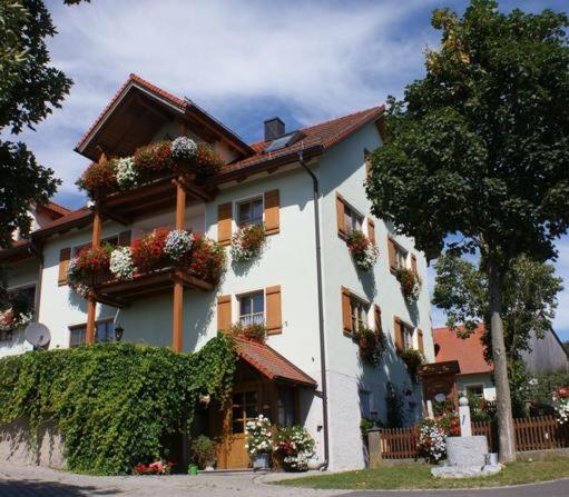 ein Gebäude mit Blumenkästen an der Seite in der Unterkunft Hanslbauernhof in Moosbach