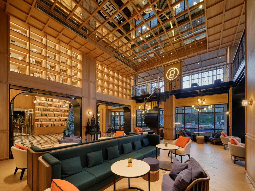 a lobby with a couch and tables and chairs at Graph Hotels Bangkok in Bangkok