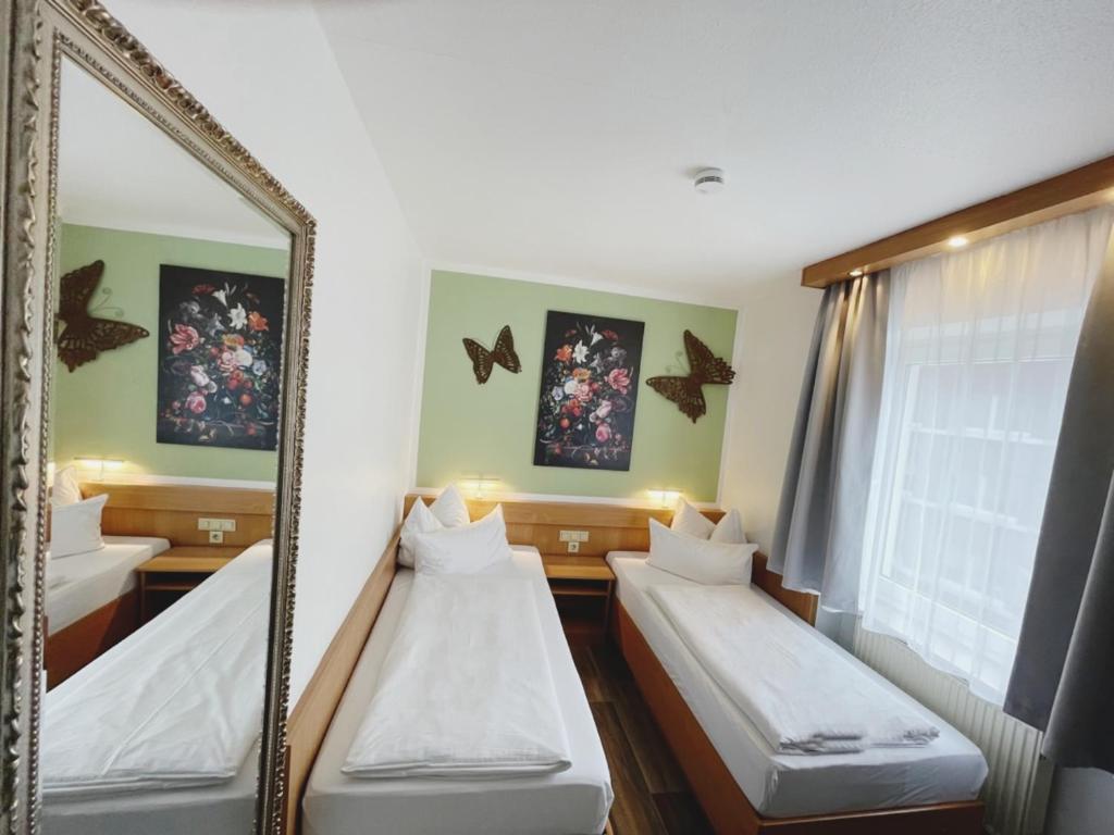 Zimmer mit 2 Betten und einem Spiegel in der Unterkunft Europa Hotel City in Saarbrücken