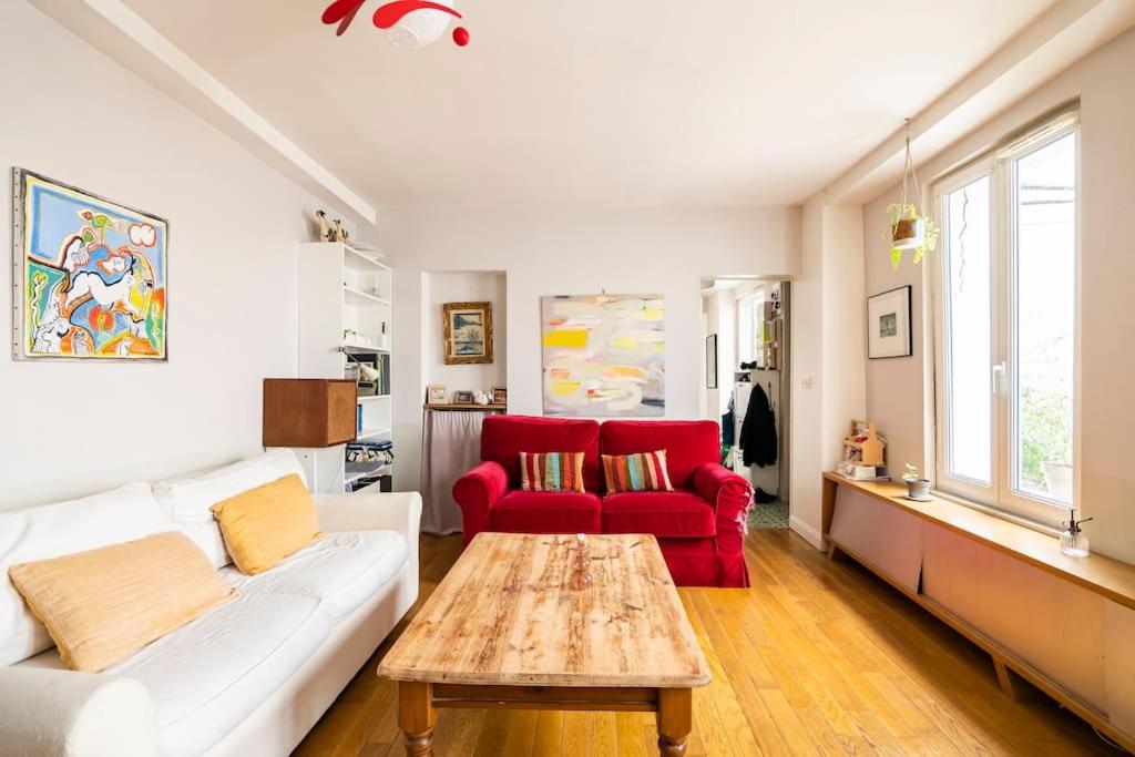 un salon avec un canapé blanc et une chaise rouge dans l'établissement Country home in Paris, à Paris