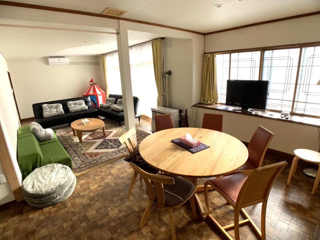 een woonkamer met een tafel en een bank bij Higashikawa home in Higashikawa