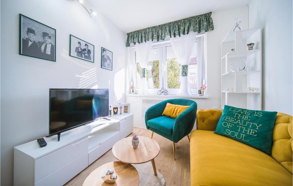 - un salon avec un canapé jaune et une télévision dans l'établissement Awesome Apartment In Varazdin With House A Panoramic View, à Varaždin