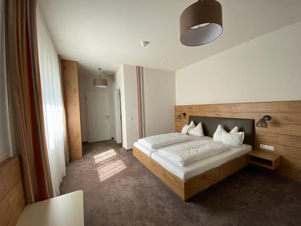 ein Schlafzimmer mit einem Bett in einem Zimmer in der Unterkunft Hotel-Pension Scharl am Maibaum in Eitting