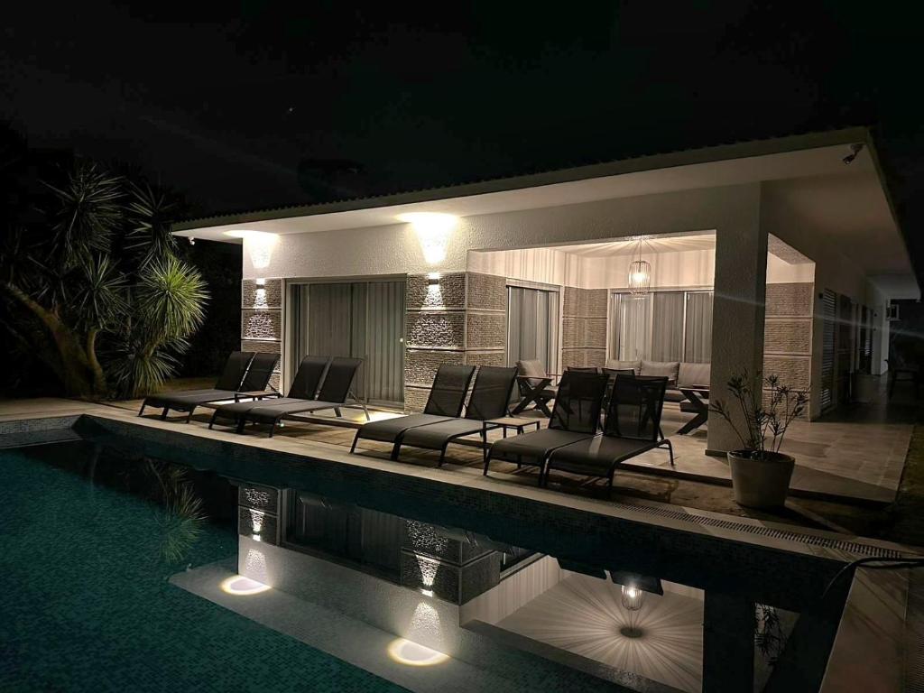 a patio with chairs and a pool at night at HESTİA ILICA in Cesme